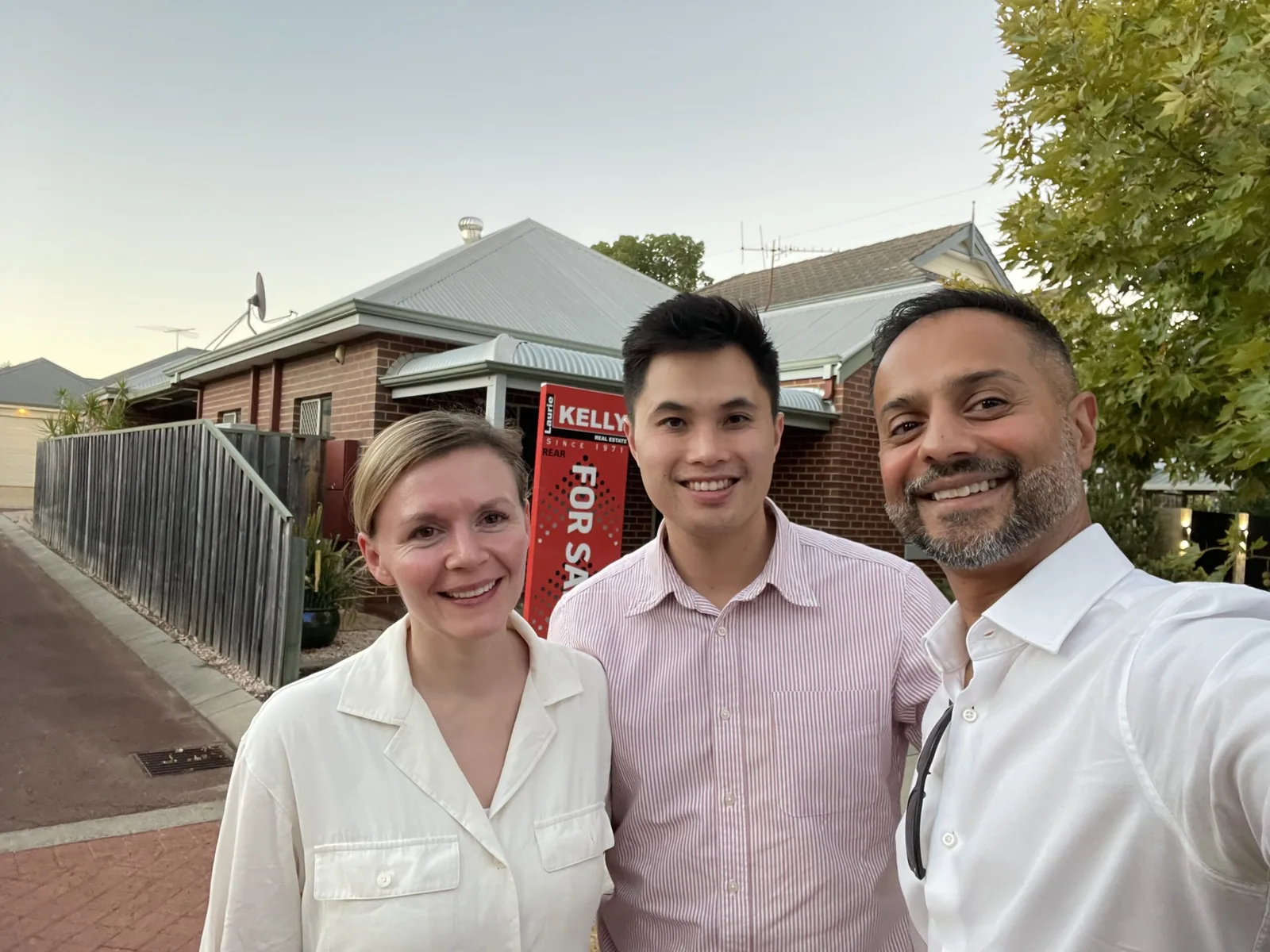 Jay Gami with a young couple outside the home they bought through Edge