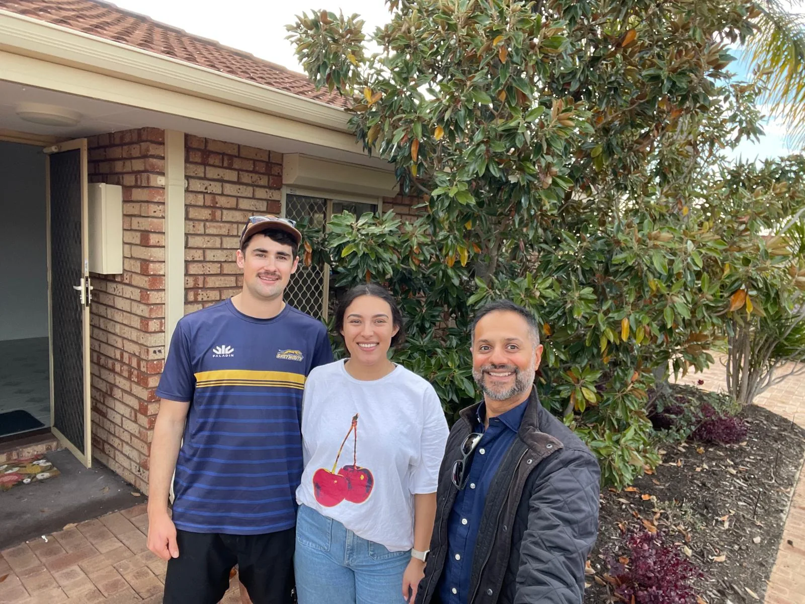 Jay Gami with clients at the front door of their new home